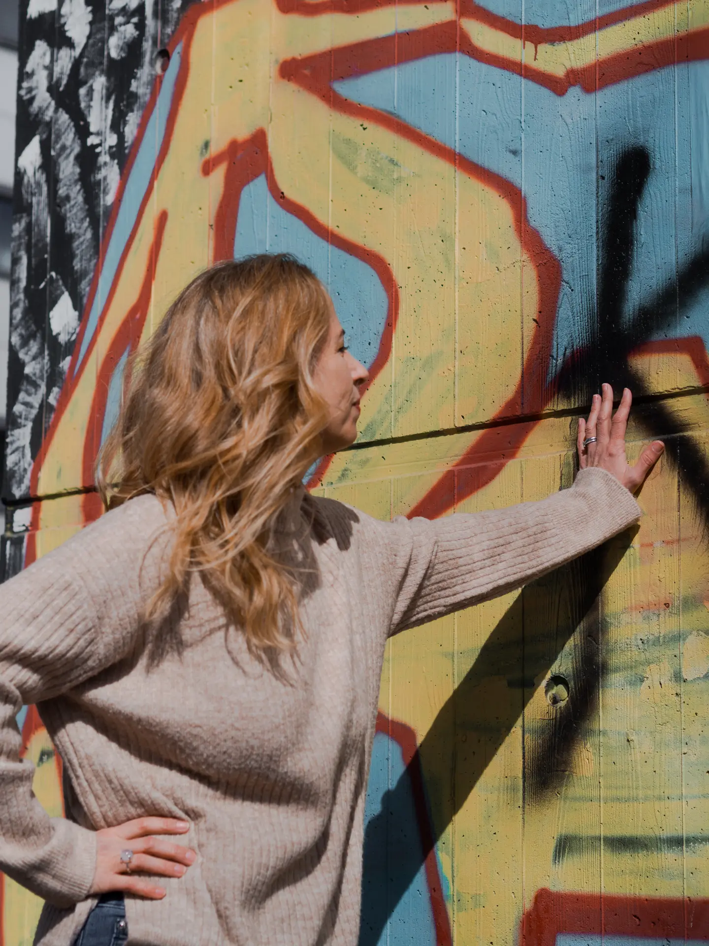 Lebensberaterin lehnt an einer Graffiti-Wand